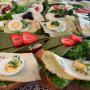 Eine große Ansammlung von belegten Brotscheiben und Canapés mit Eiern, Käse und Gemüse.